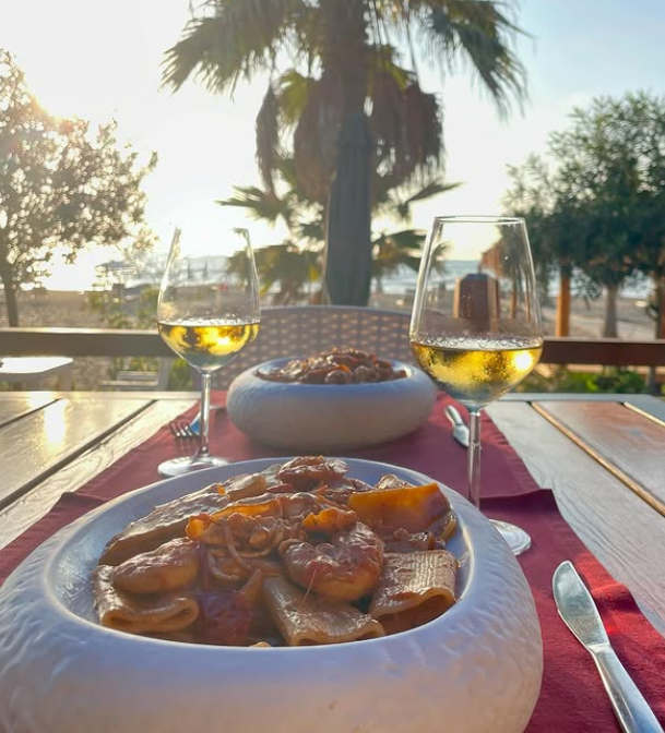 Seafood pasta and wine at sunset
